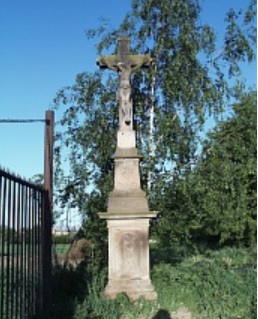 Kamenný kříž se také nachází u brány v objektu zemědělského družstva